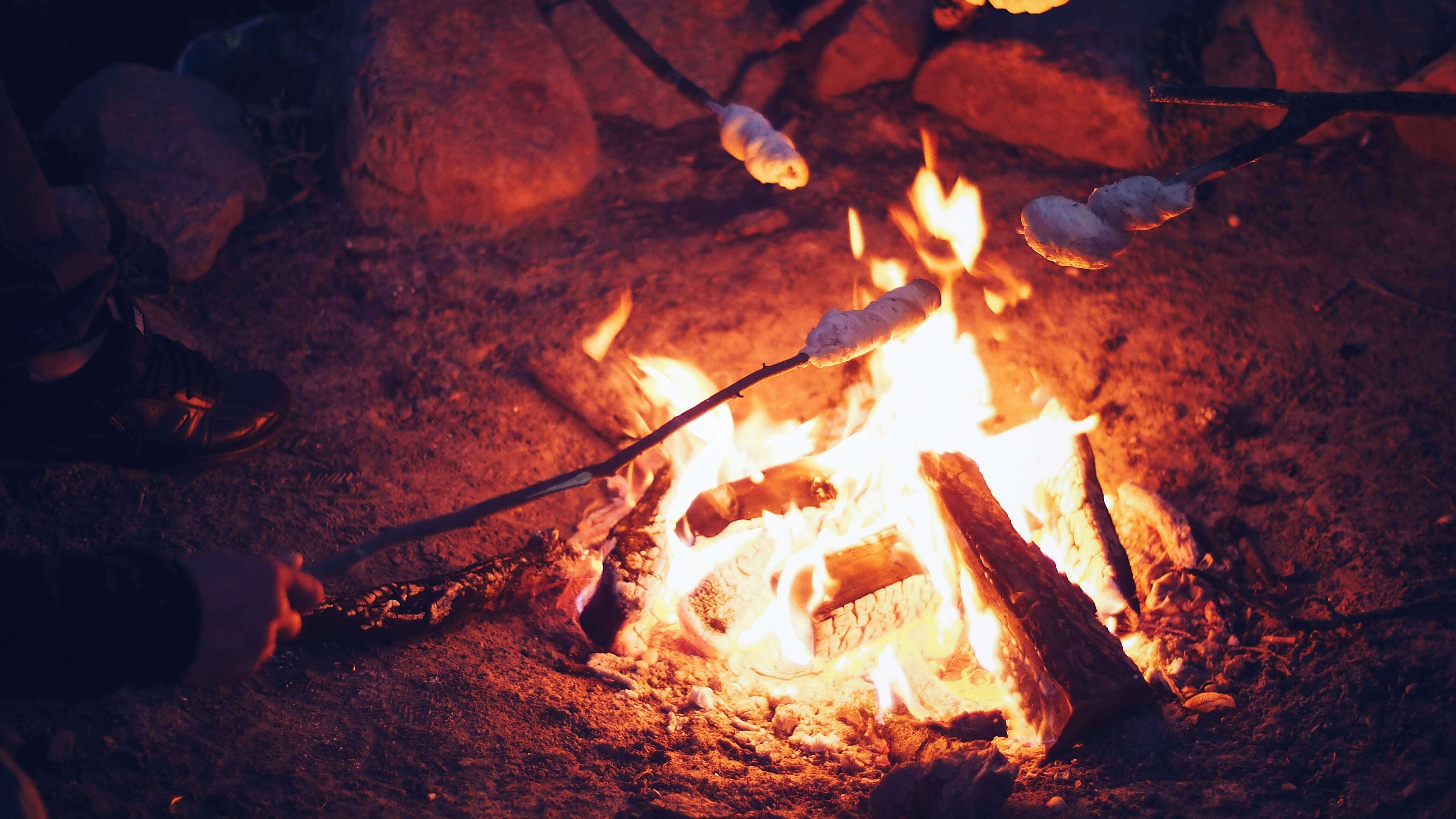 Chamallows en train de griller au dessus d'un feu de camp
