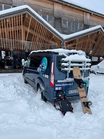 Van “L'Atypique'” couvert de neige devant une remontée mécanique