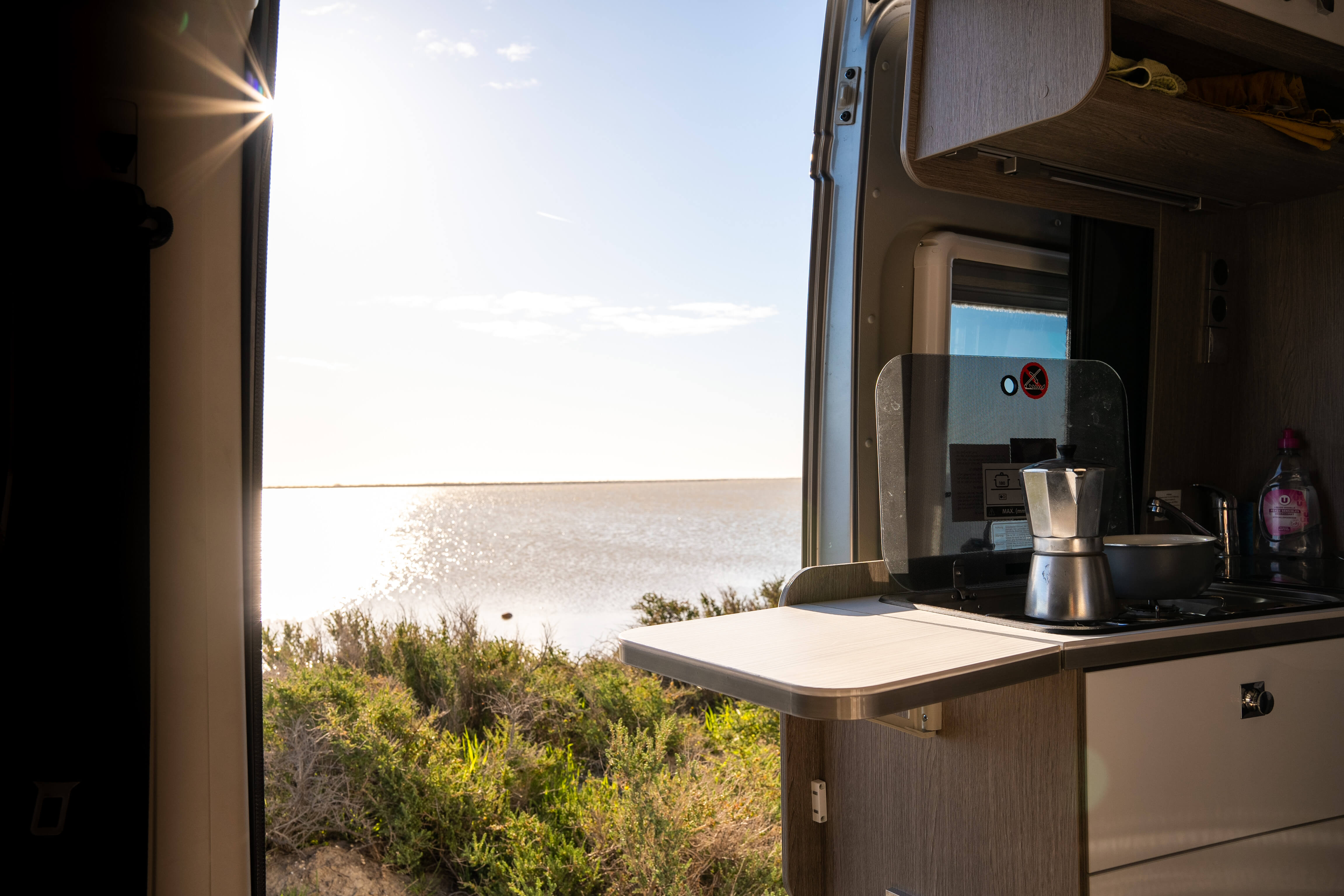 Vue sur un lac depuis l'intérieur d'un van aménagé